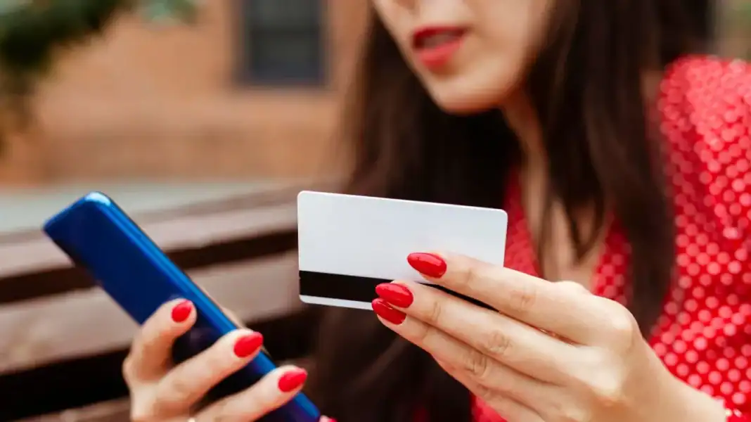 844631f1-side-view-woman-with-smartphone-credit-card-purchasing-online